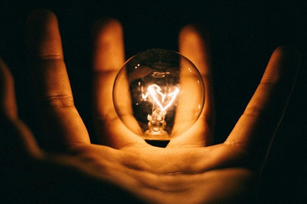 Hand holding lightbulb to illustrate ideas and inventions involved in Intellectual Property law and patent, copyright and trademark attorney in Irvine, California.