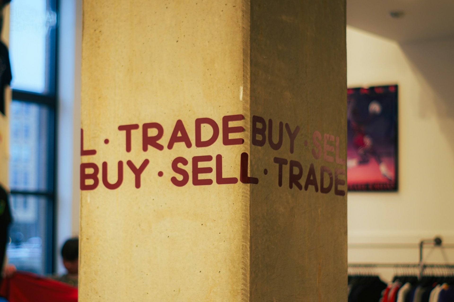 Image of vertical building column with words, "buy, sell, trade" in block letters, illustrating patent attorney services in Irvine, California.